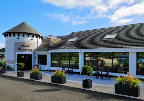 a restaurant with potted plants in front of a building at The Lodge Hotel in Coleraine