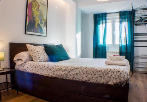 a bedroom with a large bed with blue curtains at Apartamento del pintor | Santiago in Granada