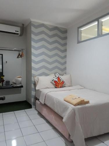 a bedroom with a bed with a striped wall at Cihampelas Homestay in Bandung