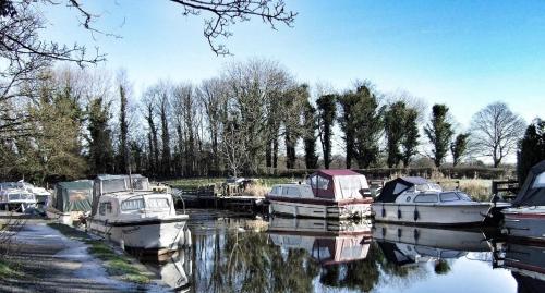 a group of boats are docked in the water at Guy's Thatched Hamlet in Barton