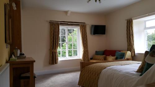 a bedroom with a bed and a window at Pontyclerc Farm House Bed and Breakfast in Ammanford