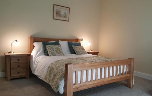 a bedroom with a wooden bed with two night stands at Pontyclerc Farm House Bed and Breakfast in Ammanford