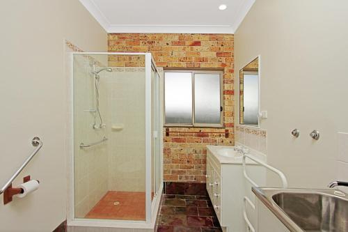 a bathroom with a shower and a sink at Chappies in Woollamia