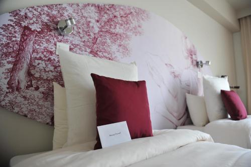 a bedroom with two beds with red and white pillows at Mercure Paris Bastille Marais in Paris
