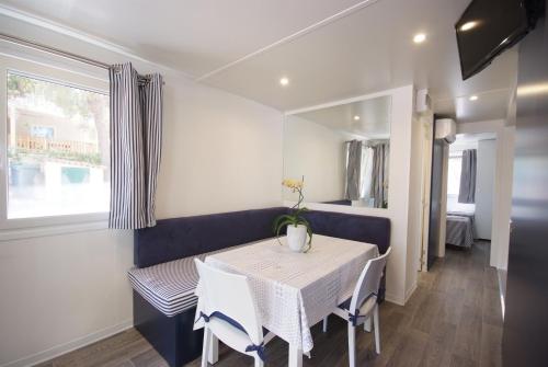 a dining room with a white table and chairs at Camping Village Le Calanchiole in Capoliveri