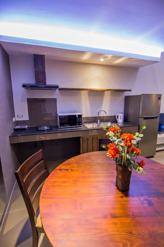 a kitchen with a wooden table with flowers on it at Quest Villa in Panglao