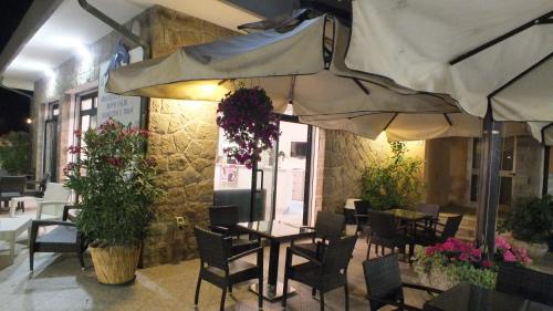 a restaurant with tables and chairs and an umbrella at Hotel Umberto in Rosolina Mare