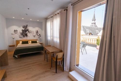 um quarto com uma cama e uma grande janela em Plaza Mayor Suites & Apartments em Madri