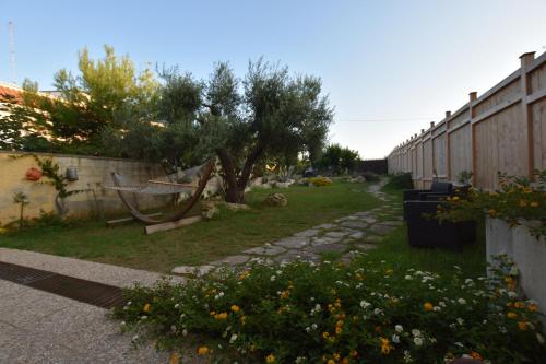 a garden with a tree and a fence at Mansarda sul Mare in Torre Lapillo