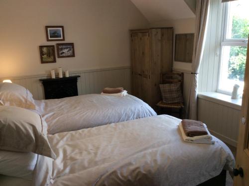 a bedroom with two beds and a window at Crown and Anchor in Dundrennan