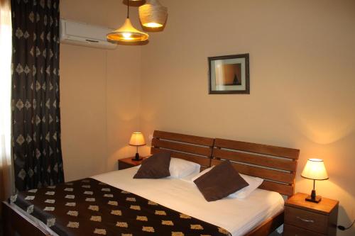 a bedroom with a bed with two lamps and a mirror at Hotel Diplomat in Tbilisi City