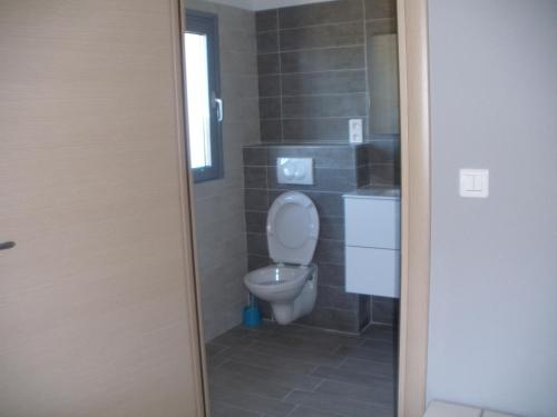 a small bathroom with a toilet and a window at Hôtel Casa di Mama in Porto-Vecchio