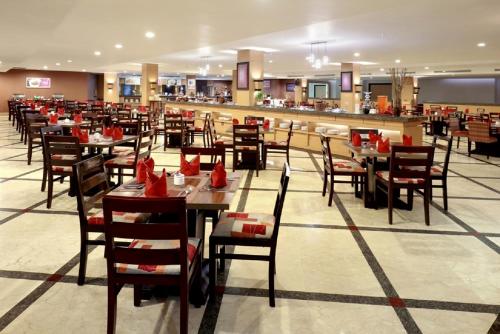 a dining room with tables and chairs in a restaurant at Swiss-Belinn Panakkukang in Makassar
