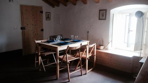 a dining room with a table with chairs and a window at Casa da Vila in Castelo de Vide