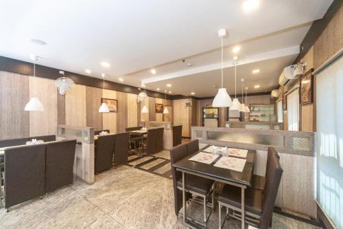 a restaurant with a dining room with tables and chairs at Hotel Sumi Palace in Thanjāvūr