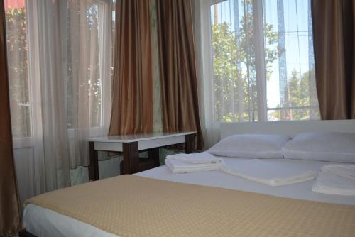 a bedroom with a bed and a window with curtains at hotel niks in Makhinjauri