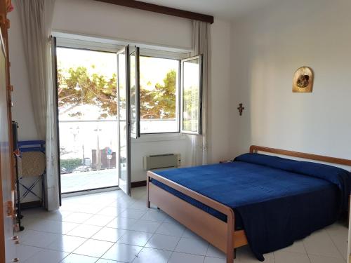 een slaapkamer met een blauw bed en een groot raam bij Alassio Sea View in Alassio