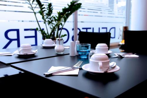 a black table with plates and silverware on it at Hotel Deutscher Hof in Kassel