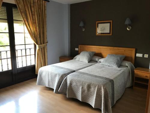 1 dormitorio con 2 camas y ventana en Casa Martín, en Poza de la Sal