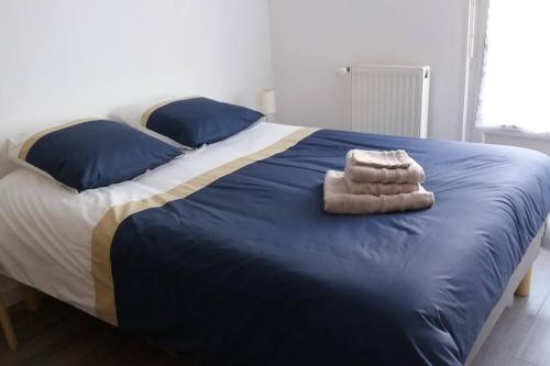 un lit avec deux serviettes dessus dans l'établissement Le Vivier appartement avec parking, à Boulogne-sur-Mer