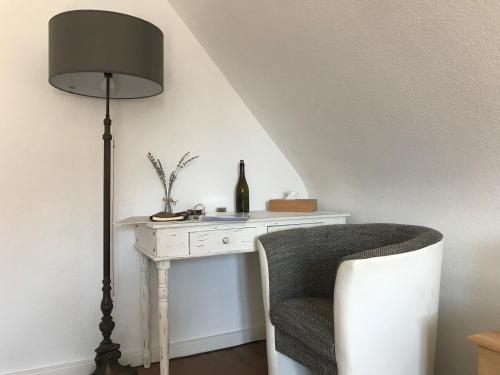 a white desk with a lamp and a chair at Ferienwohnung Haltingen in Weil am Rhein