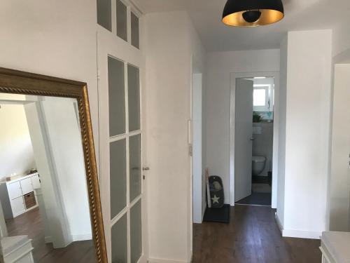 a hallway with a mirror and a bathroom at Ferienwohnung Haltingen in Weil am Rhein