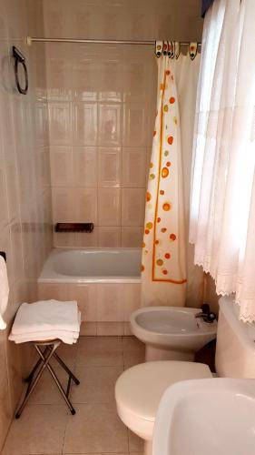 ein Badezimmer mit Badewanne, Toilette und Waschbecken in der Unterkunft Hotel Villa in Isla