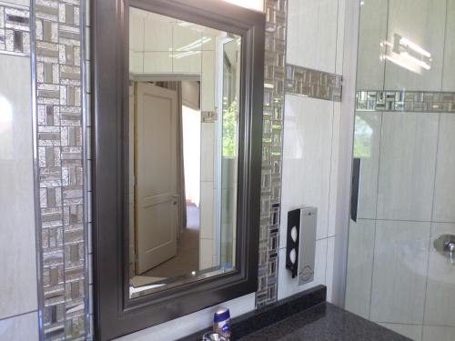 a bathroom with a mirror and a sink at The Links Guest House in Pretoria