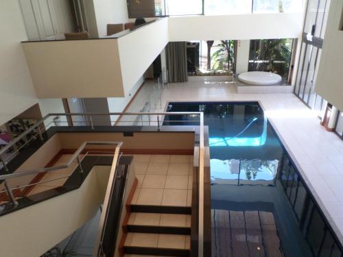 a house with a pool in the middle of a building at The Links Guest House in Pretoria