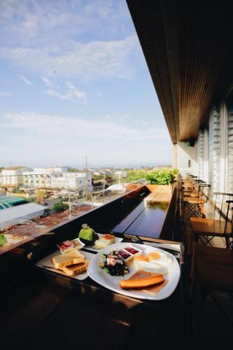 a table with plates of food on a balcony at Laekhon Nonbai in Nakhon Si Thammarat