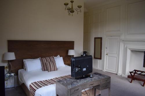 ein Schlafzimmer mit einem Bett und einem TV auf einem Tisch in der Unterkunft Telford Madeley Court Hotel in Telford