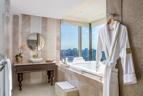 a bathroom with a tub and a sink and a mirror at Pan Pacific Yangon in Yangon