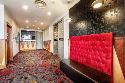 
a red carpeted room with a red couch and a red rug at Nightcap at Findon Hotel in Adelaide
