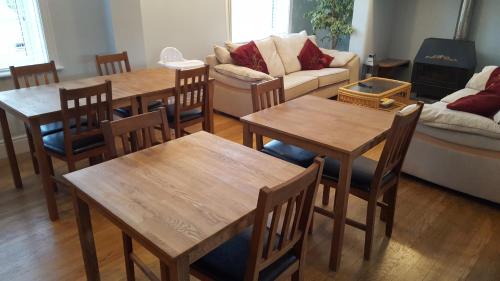 Woodlands 159 في برشور: غرفة معيشة مع طاولات وكراسي وأريكة