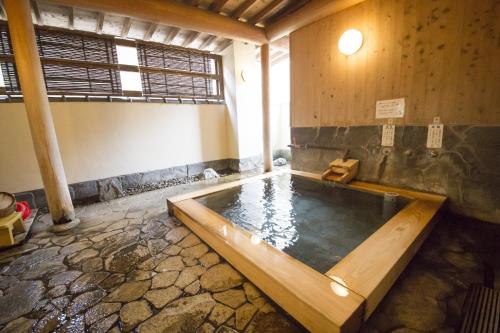 a large bath tub in a room with at Nogami Honkan in Beppu