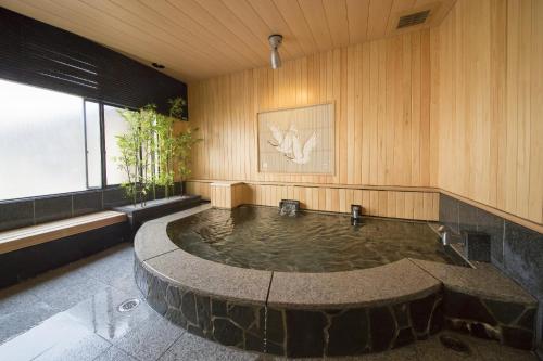 una piscina de agua en una habitación con paredes de madera en Nogami Honkan en Beppu