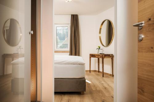 a bedroom with a bed and a mirror at Emma's kleines Hotel in Ramsau im Zillertal