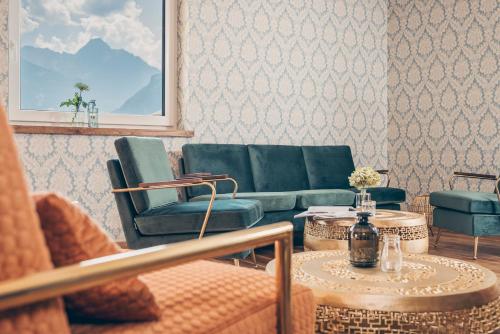 a living room with a couch and chairs and a table at Emma's kleines Hotel in Ramsau im Zillertal