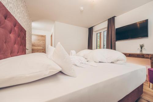a bedroom with two beds with white pillows at Emma's kleines Hotel in Ramsau im Zillertal