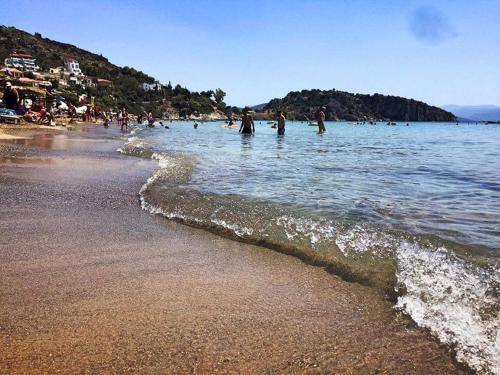 a group of people in the water at a beach at ANGELO Cafe Hotel in Tolo