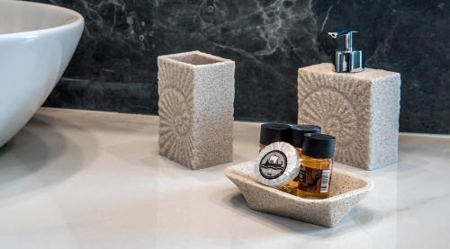 a bathroom with three soap dispensers and a sink at Hotel Thissio in Athens