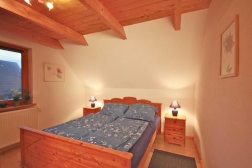 een slaapkamer met een bed met blauwe lakens en een raam bij Ferienwohnung Schauf in Gelting