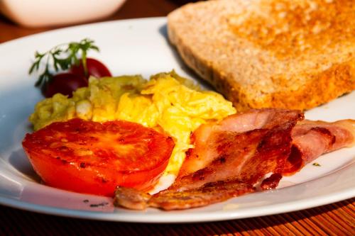 a plate of breakfast food with eggs bacon and toast at La Lechere Guest House in Phalaborwa