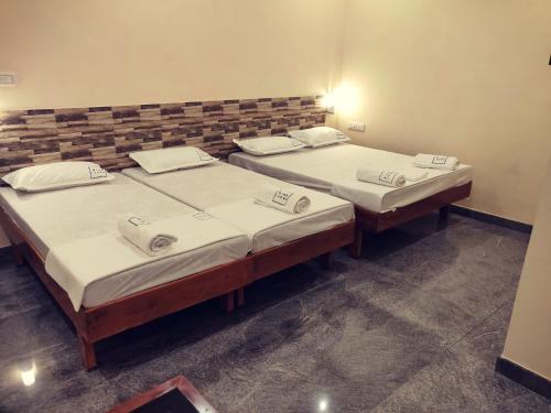 two twin beds in a room with at Hotel Wins in Kanyakumari