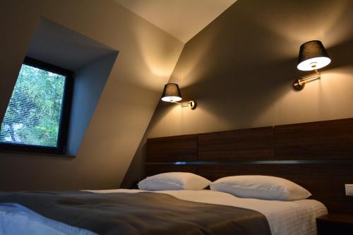 a bedroom with a bed with two pillows and two lights at Hotel Garnet Tbilisi in Tbilisi City