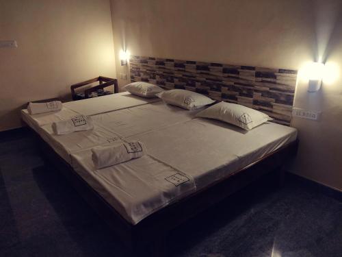 a large bed with two pillows on it in a room at Hotel Wins in Kanyakumari