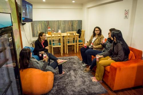 a group of women sitting in a room playing a video game at Hostal Casa Aborigen in Santiago