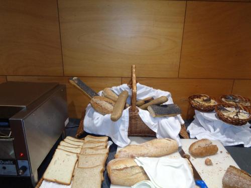 a table topped with bread and a basket of bread at BIO Hotel - Hotel Quinta da Serra in Estreito de Câmara de Lobos