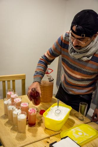 a man standing at a table with a bunch of drinks at Hostal Casa Aborigen in Santiago
