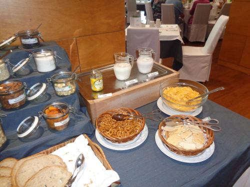a table topped with baskets of food and bread at BIO Hotel - Hotel Quinta da Serra in Estreito de Câmara de Lobos